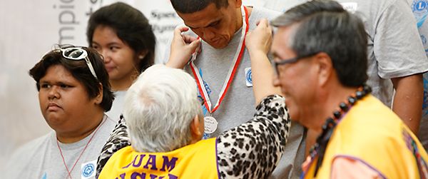 A young Special Olympics athlete receives a silver medal